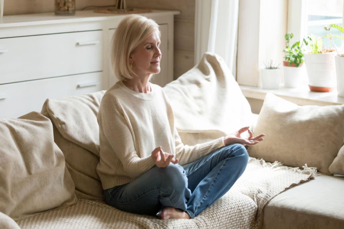 Senior Woman Meditating on Sofa