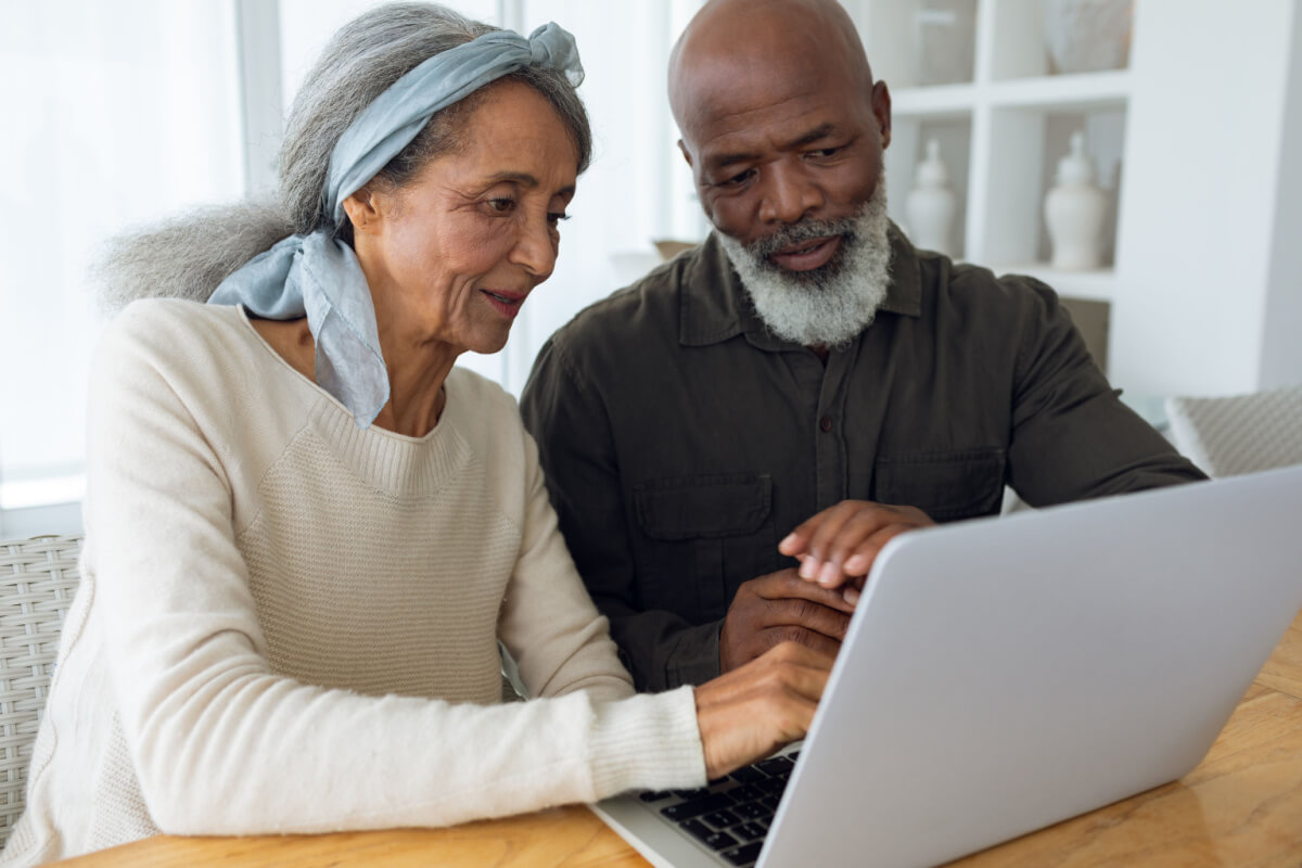 Older couple researching senior living options on a laptop computer