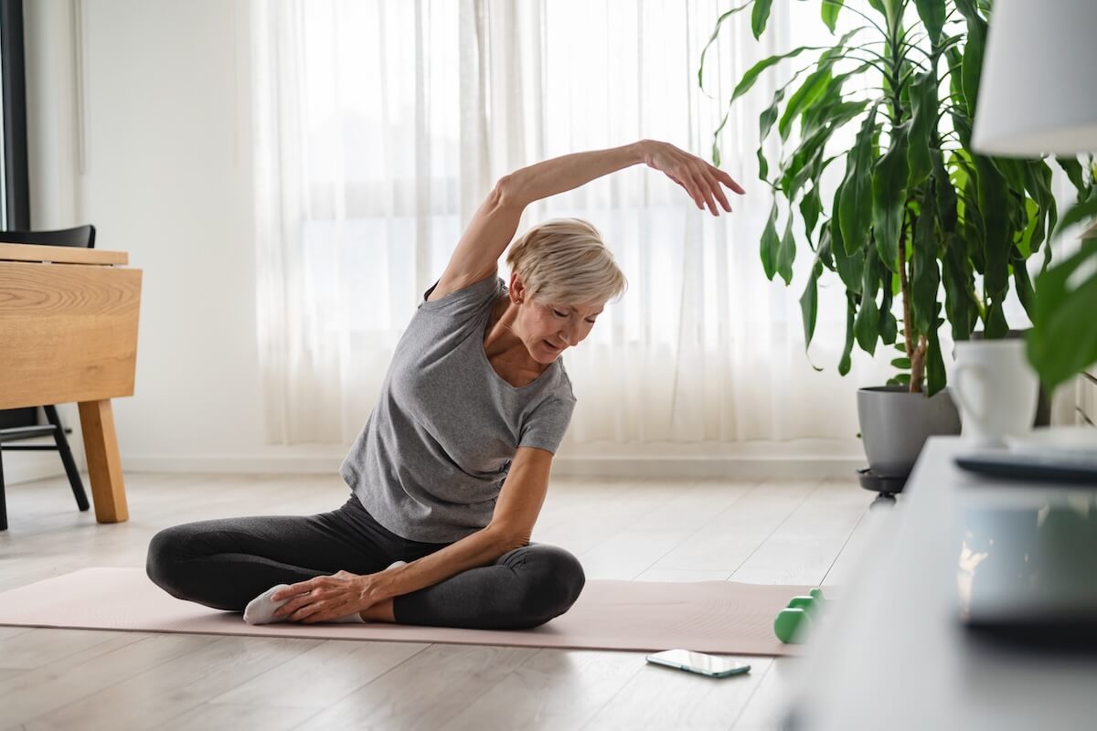 Active senior woman stretching and exercising indoors. holistic wellness for older adults